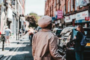 Person in raincoat and hat walking in London.