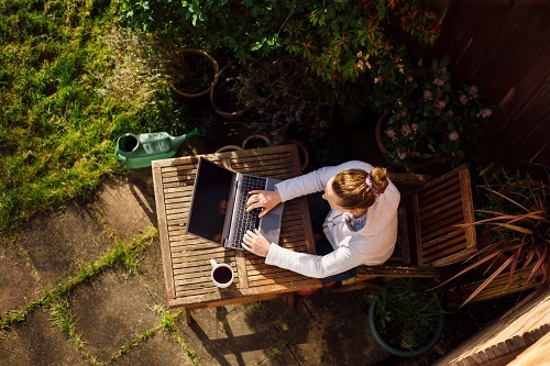 Woman in garden on laptop
