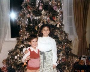 Brother and sister by Christmas tree.