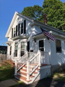 White house with black shutters and american flag