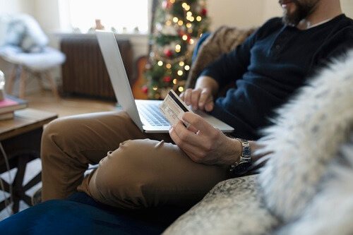 Man holding credit card while on laptop