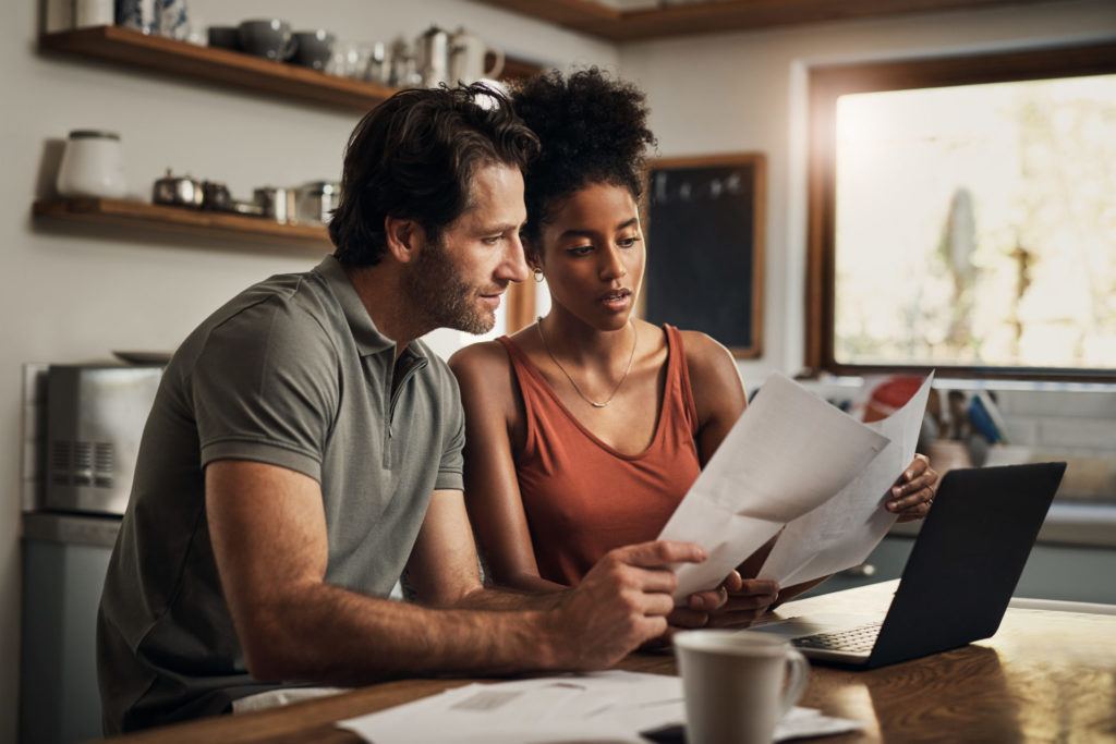 Couple doing paperwork at table.