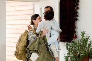 Female soldier hugging family