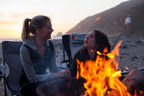 Two girls by camp fire
