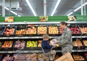 Female soldier shopping in grocery store with son