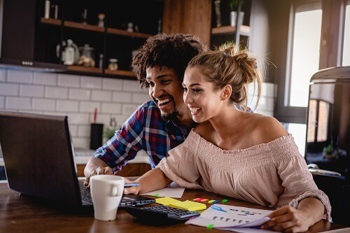 Couple looking at laptop smiling