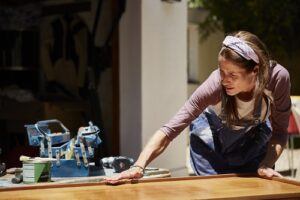 Woman polishing furniture outdoors