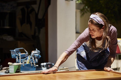 Woman polishing furniture outdoors