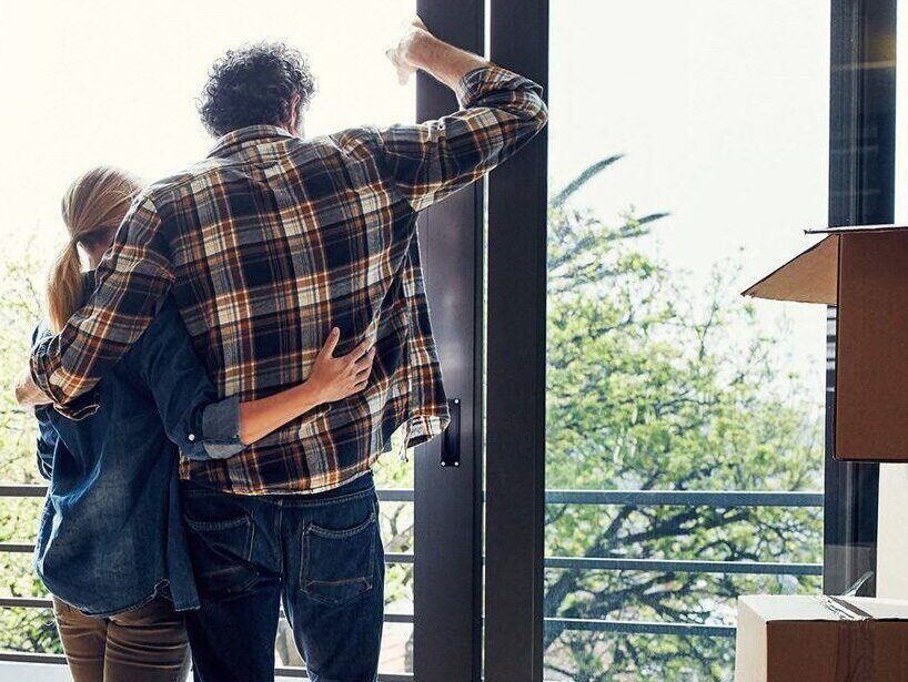 Man and woman embracing in a home with moving boxes