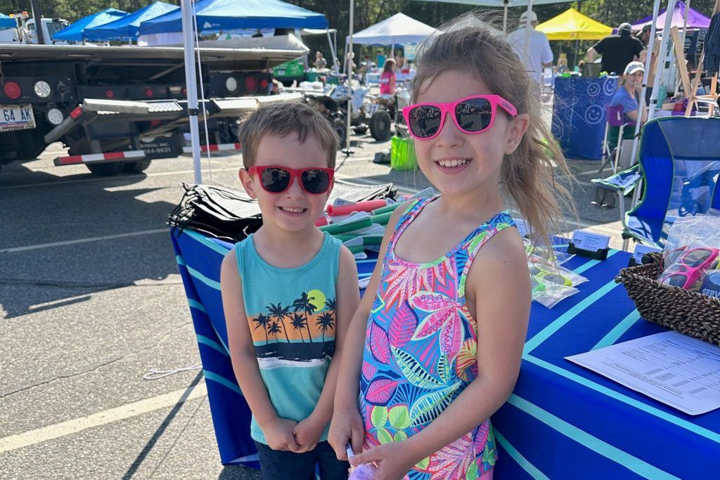 Two kids enjoying their new Service CU sunglasses at the Touch-A-Truck Fundraiser.