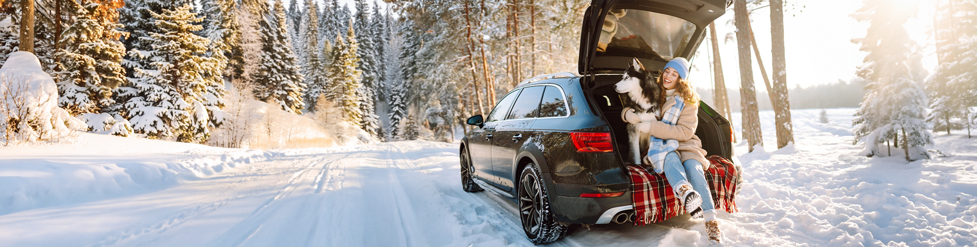 Woman and her dog sitting in car on snowy day