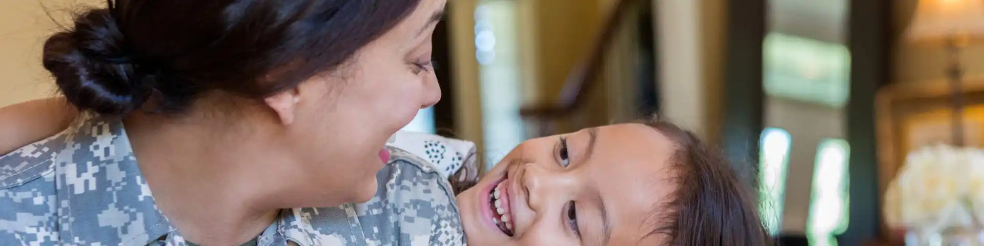 veteran mother looking down at her smiling child