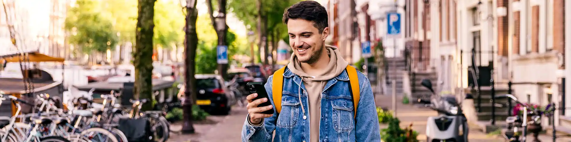man smiling at his cellphone while going for a walk