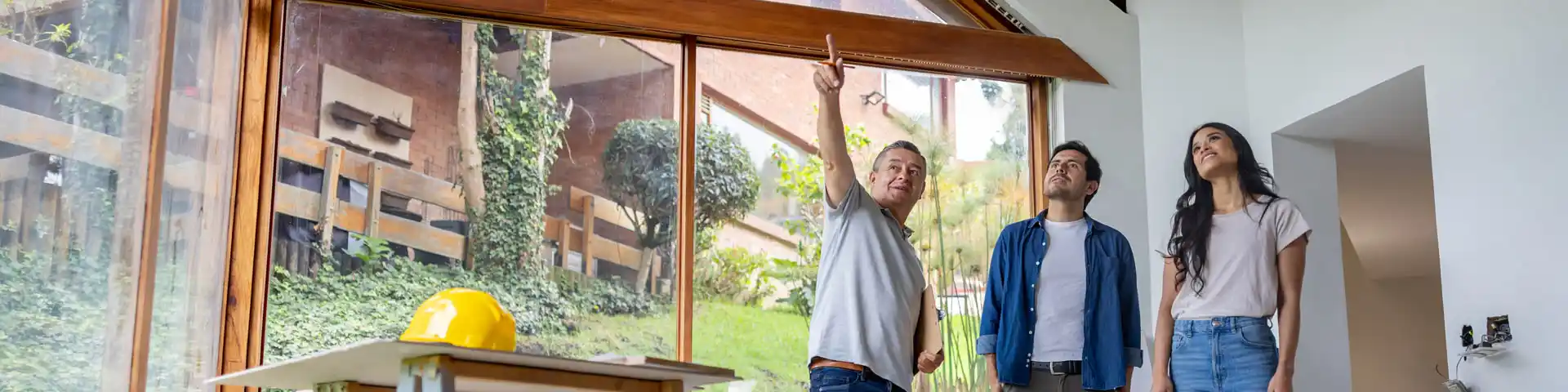 homeowners and a contractor inspecting the ceiling of their home