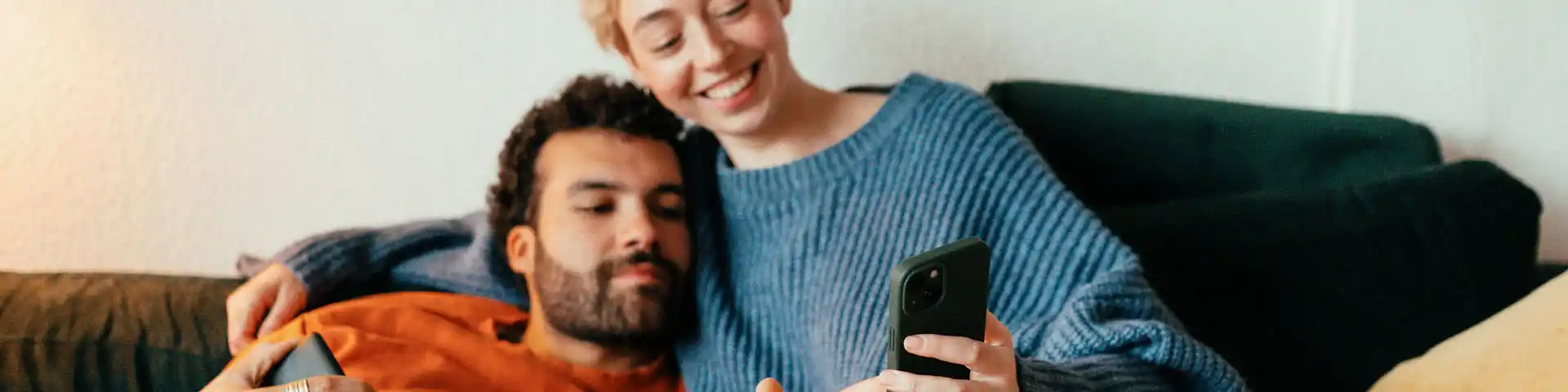 couple relaxing on the couch looking at a cellphone