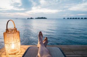 legs outstretched and relaxing on a pier